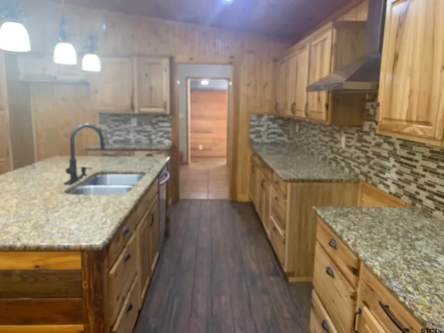 a kitchen with granite countertop a sink stove and cabinets