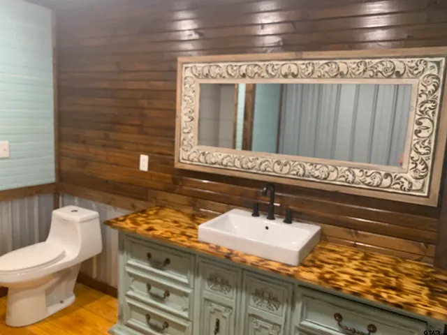 a bathroom with a granite countertop toilet and sink