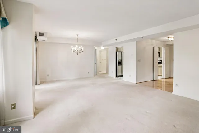 an empty room with a cabinet and mirrors