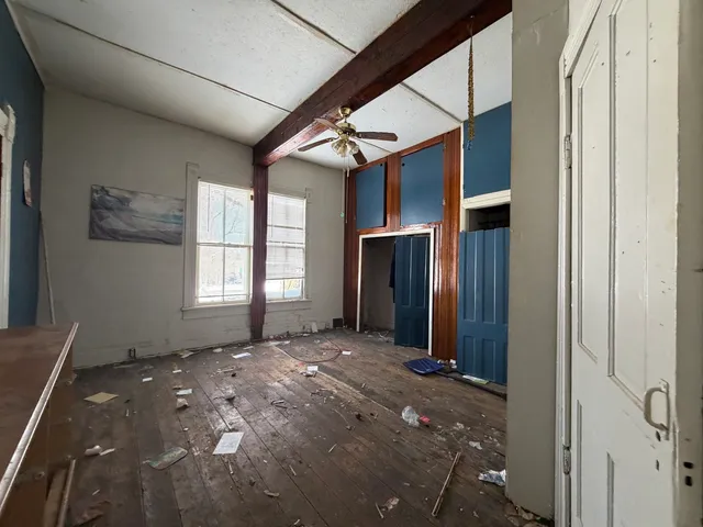 a view of an empty room with a fireplace and a window
