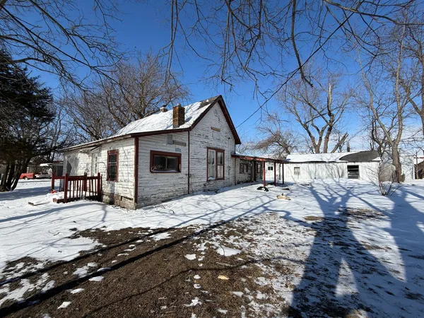 a front view of a house with a yard covered in snow