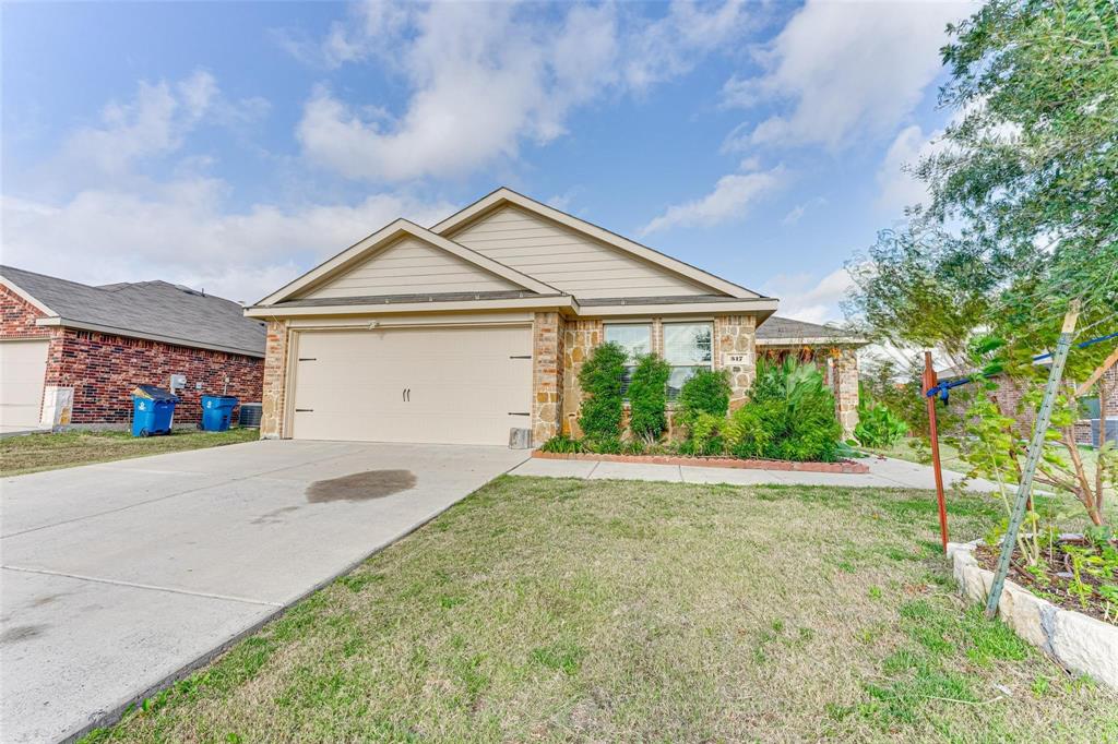 517 Milo Way Royse City, TX 75189 - Photo 34 of 34 Single-story residence featuring a two-car garage, stone and siding exterior, concrete driveway, front yard with mature landscaping, and a covered entry porch