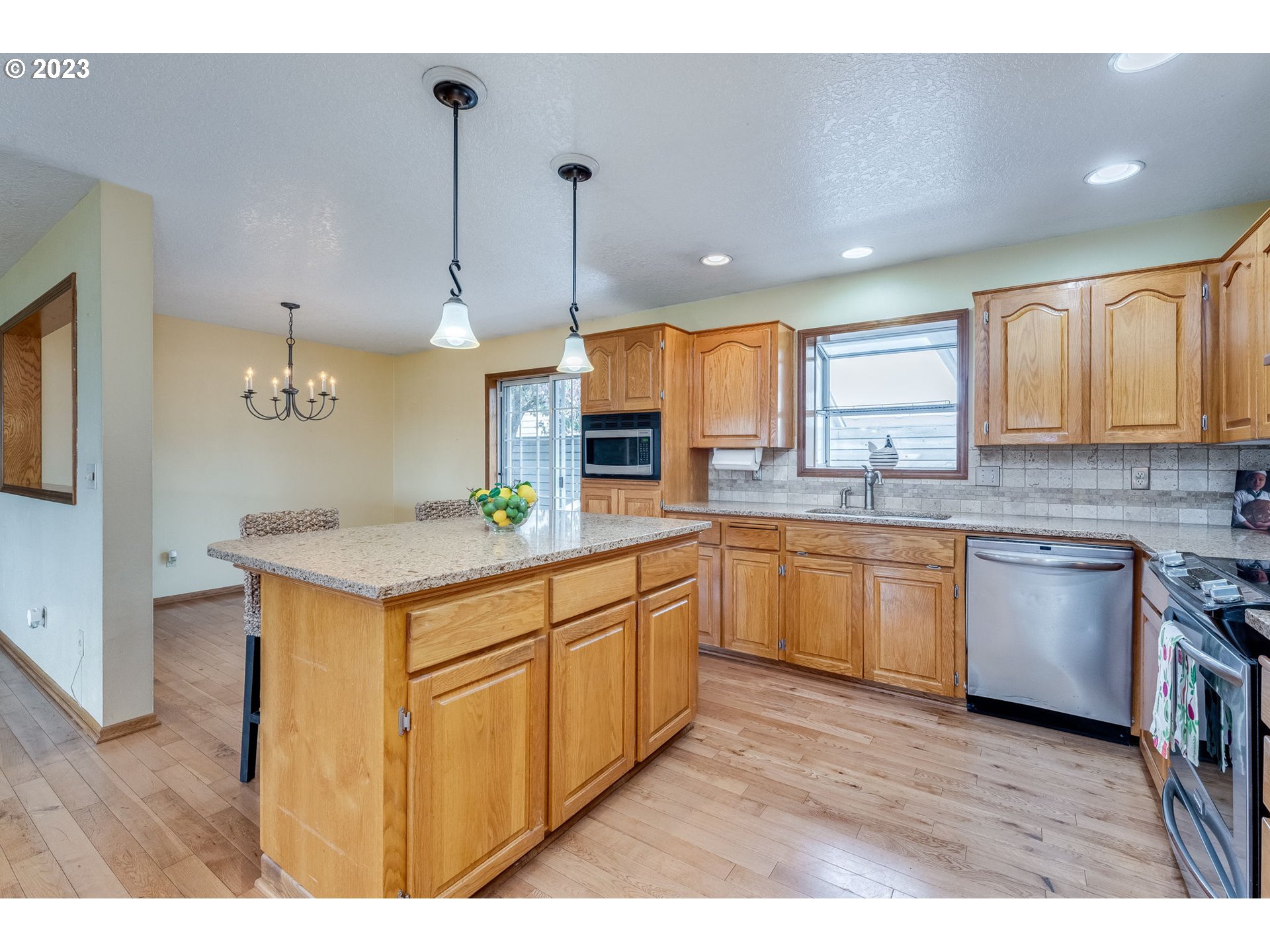 1740 North Laurelwood Loop Canby, OR 97013 - Photo 13 of 46 a kitchen with stainless steel appliances granite countertop a sink a stove a refrigerator a center island and cabinets