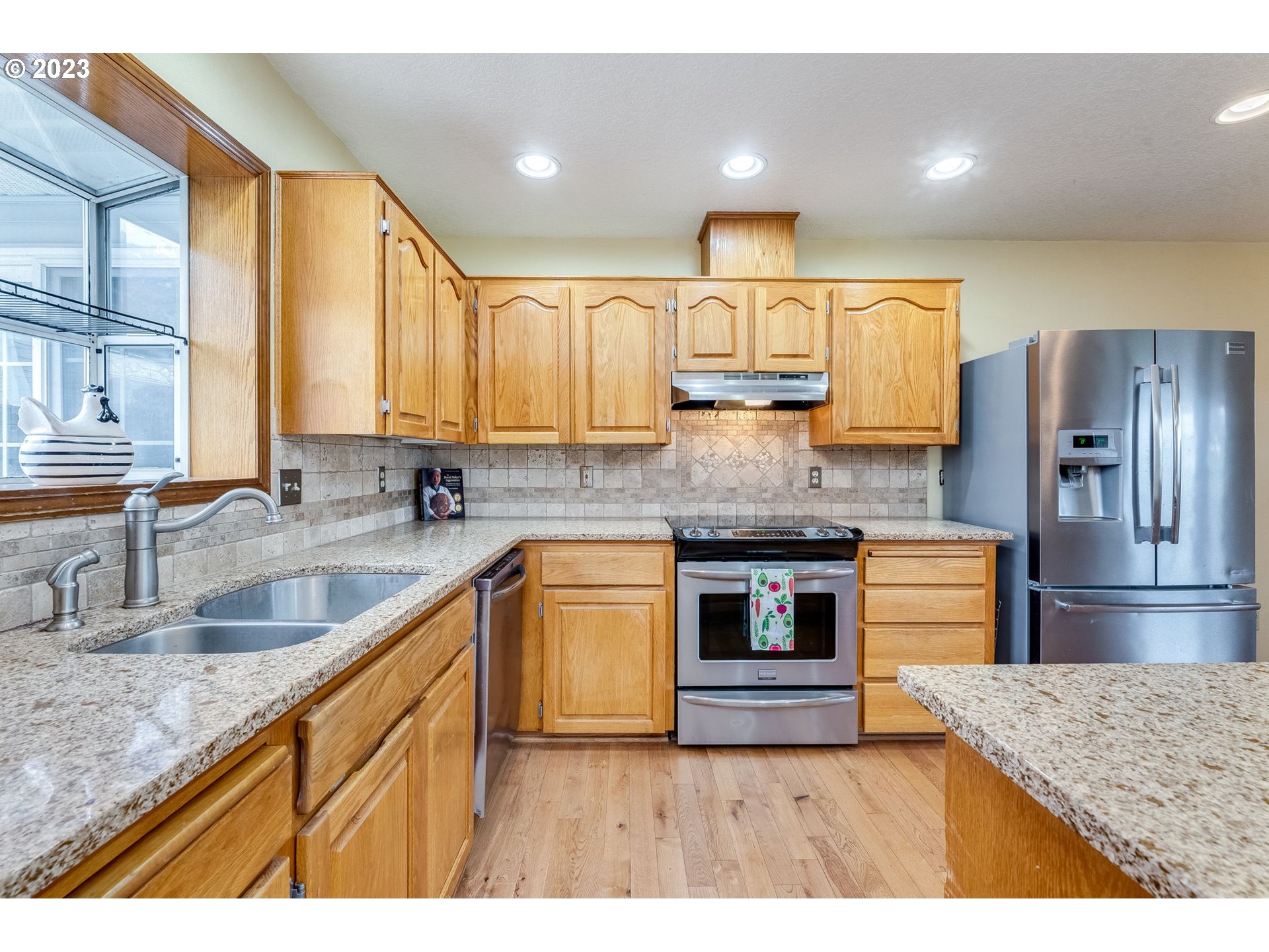 1740 North Laurelwood Loop Canby, OR 97013 - Photo 16 of 46 a kitchen with stainless steel appliances granite countertop a sink stove and refrigerator