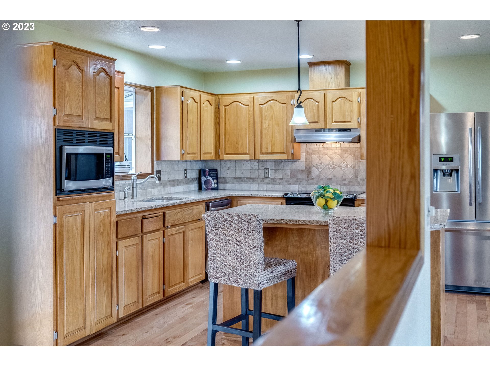 1740 North Laurelwood Loop Canby, OR 97013 - Photo 17 of 46 a kitchen with stainless steel appliances granite countertop a sink a stove a refrigerator cabinets and chairs