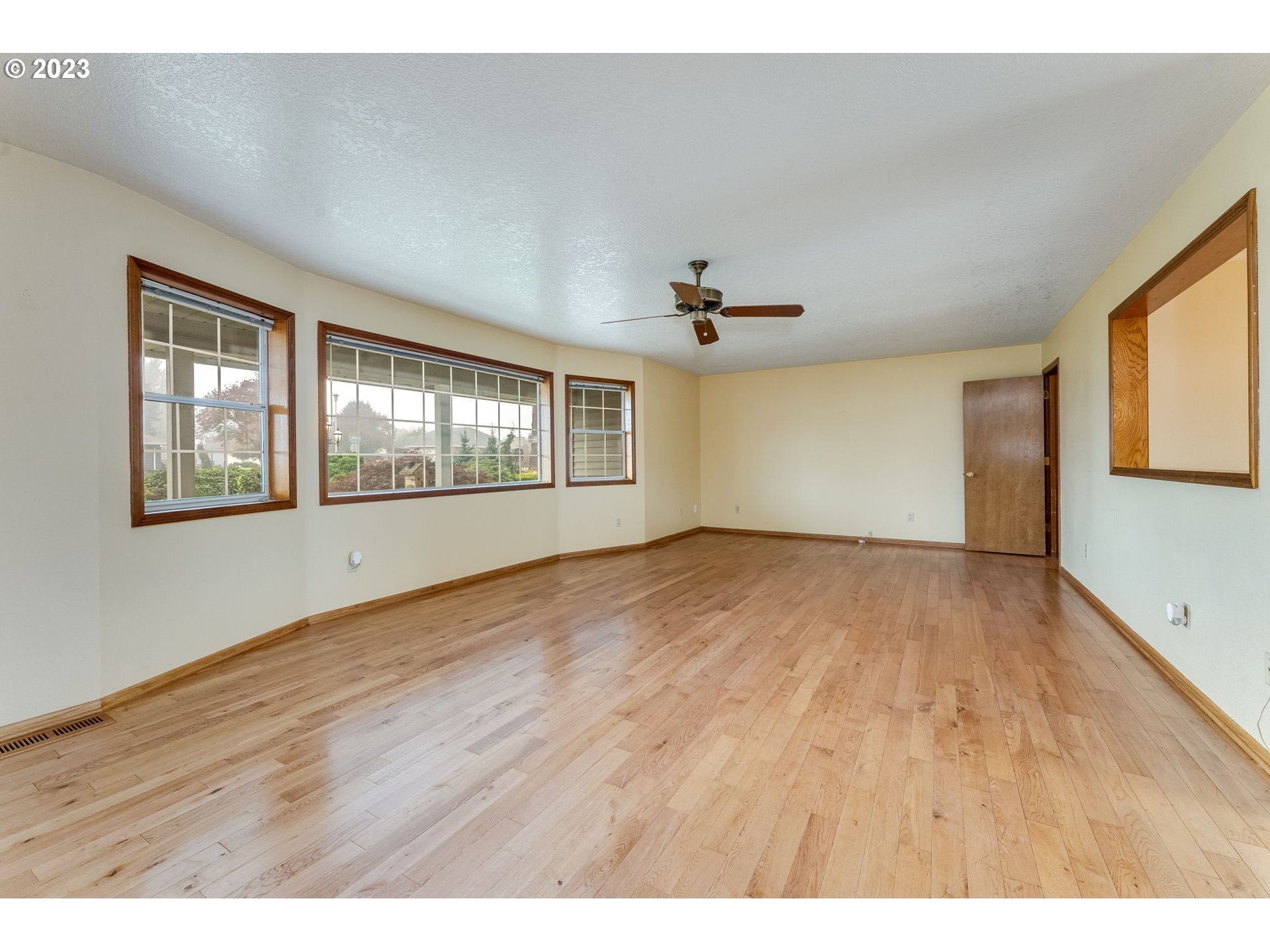 1740 North Laurelwood Loop Canby, OR 97013 - Photo 7 of 46 a view of an empty room with a window and wooden floor