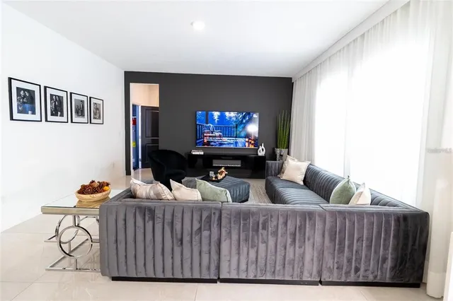 a living room with furniture a window and a flat screen tv