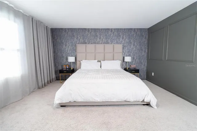 a large bed sitting in a bedroom next to a window