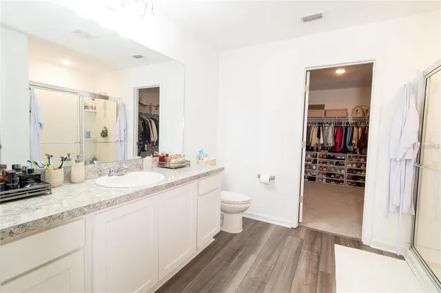 a bathroom with a granite countertop sink toilet and shower