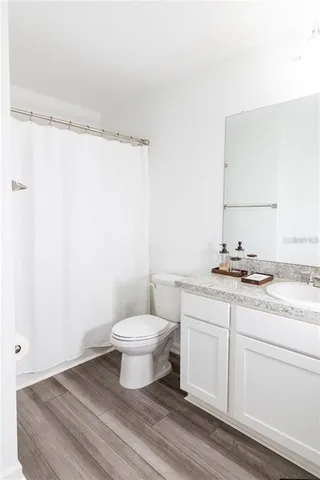 a bathroom with a granite countertop sink toilet and a mirror