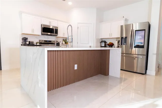 a kitchen with stainless steel appliances a refrigerator and a stove top oven
