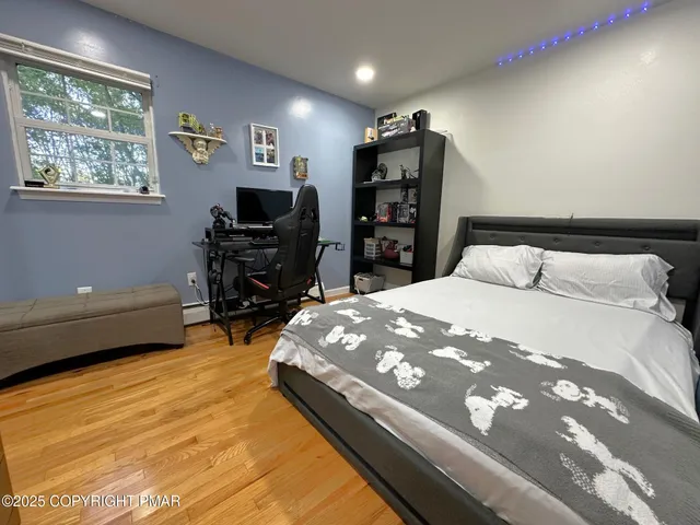 a bedroom with a bed a dresser and a flat screen tv