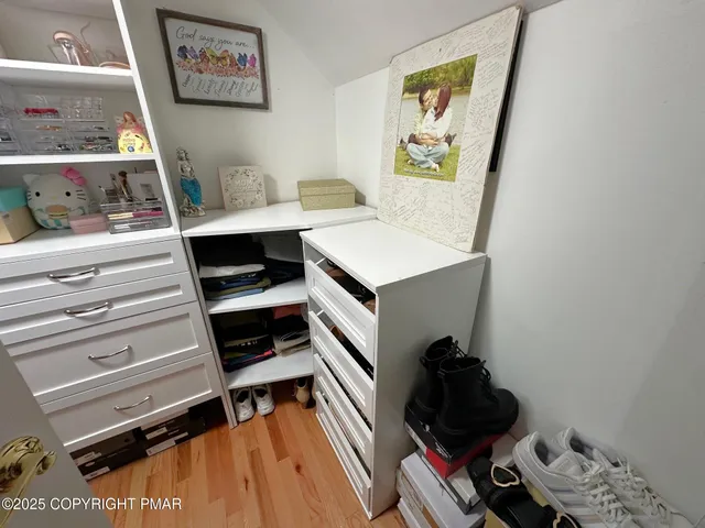 a view of walk in closet with clothes and shoes