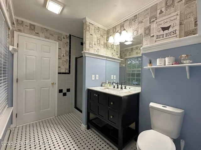 a bathroom with a sink vanity granite toilet and shower