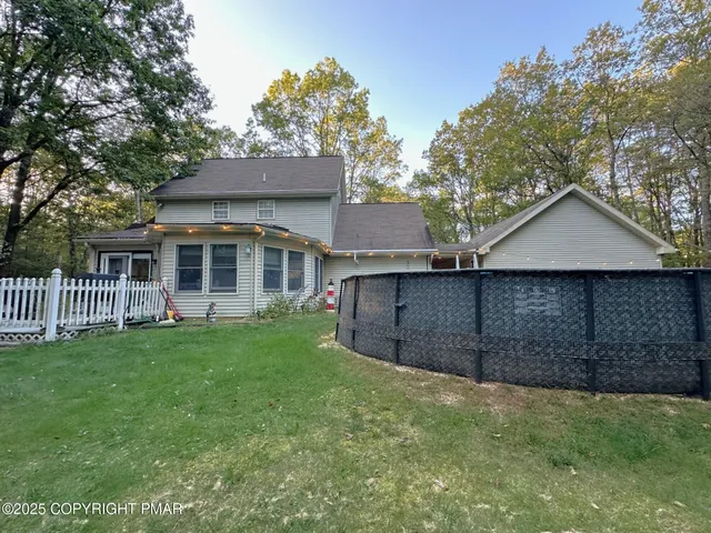a view of a yard in front of a house with a large tree