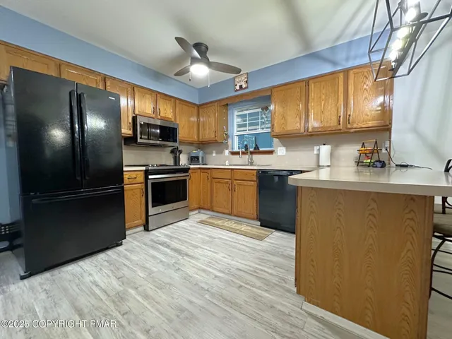 a kitchen with stainless steel appliances granite countertop a sink stove refrigerator and cabinets