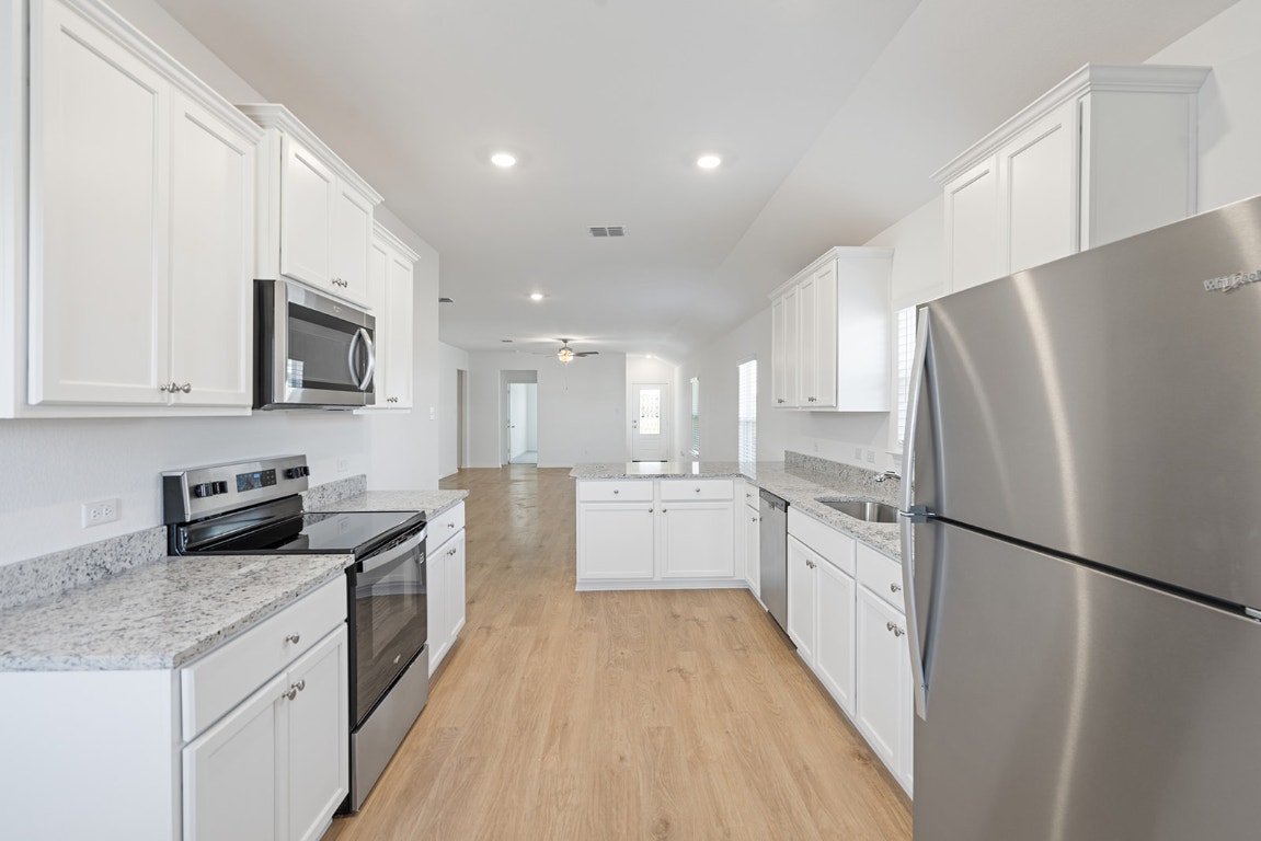 112 Paria Court Jarrell, TX 76537 - Photo 3 of 7 a large kitchen with a refrigerator a sink a stove top oven and cabinets