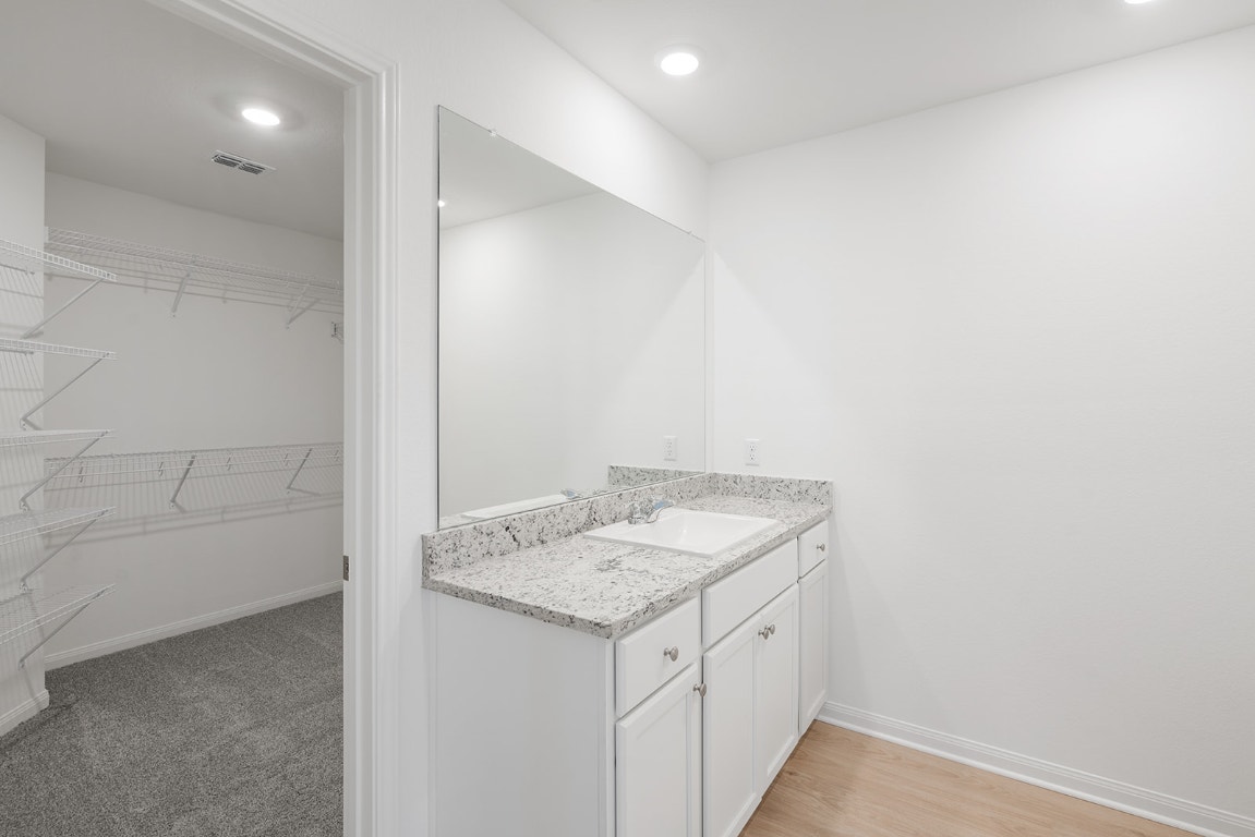 112 Paria Court Jarrell, TX 76537 - Photo 6 of 7 a bathroom with a granite countertop sink and a mirror