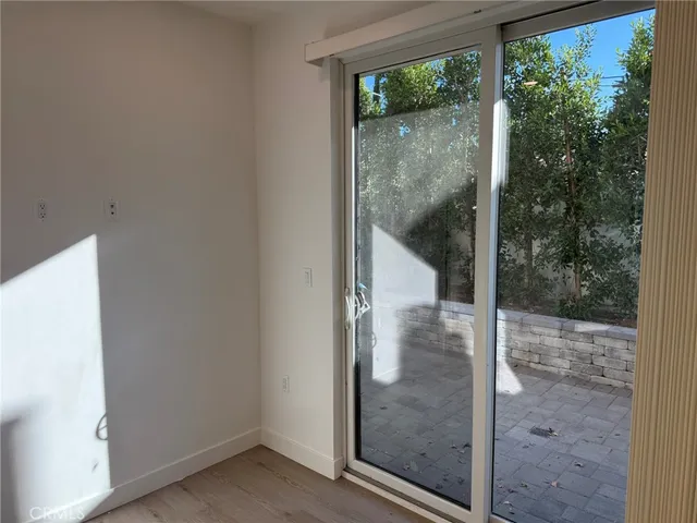 an empty room with wooden floor and mirror