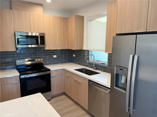 a kitchen with a sink stove and refrigerator