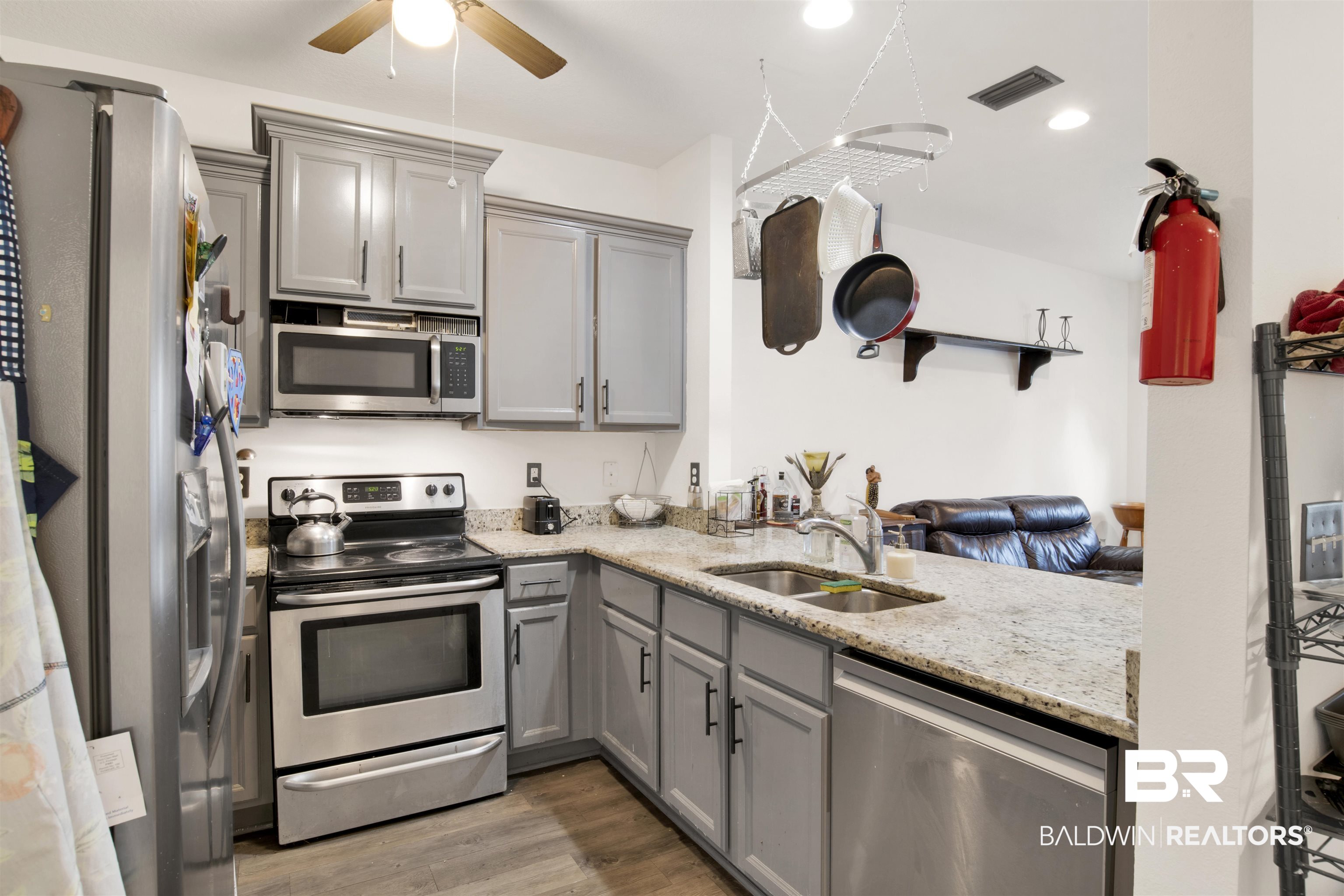 25806 Pollard Road, Unit 80 Daphne, AL 36526 - Photo 15 of 30 Kitchen with gray cabinetry, appliances with stainless steel finishes, light stone countertops, a ceiling fan, and light wood finished floors