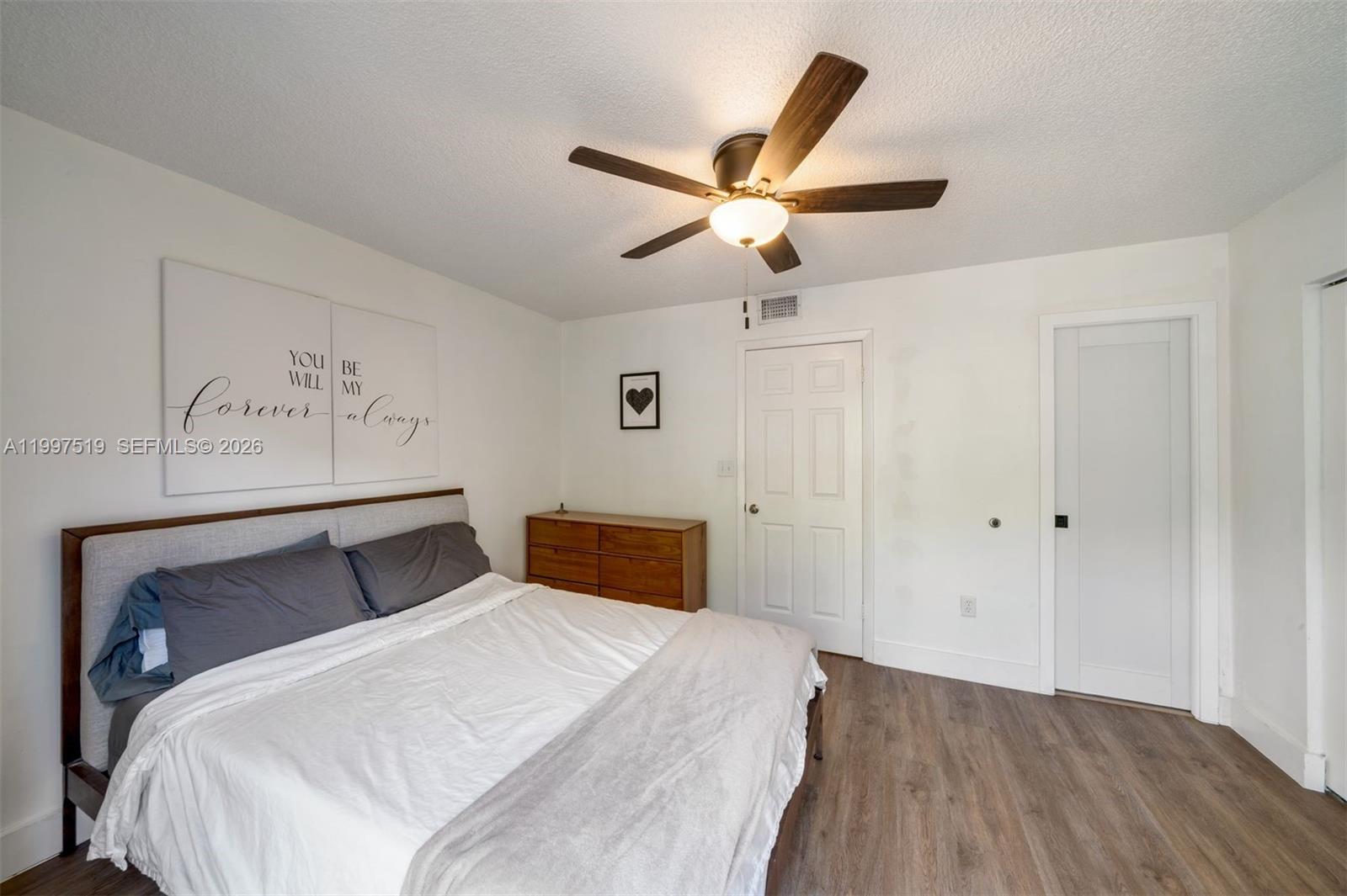 10415 Southwest 154th Court, Unit 2 Miami, FL 33196 - Photo 16 of 27 a bedroom with a bed and painting on the wall