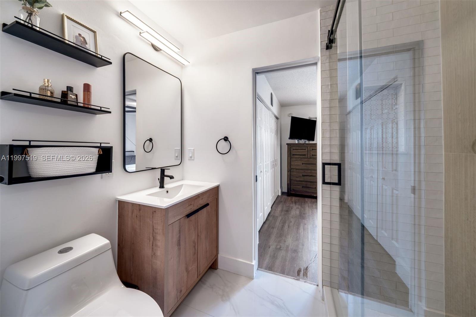 10415 Southwest 154th Court, Unit 2 Miami, FL 33196 - Photo 19 of 27 a bathroom with a sink a toilet and mirror