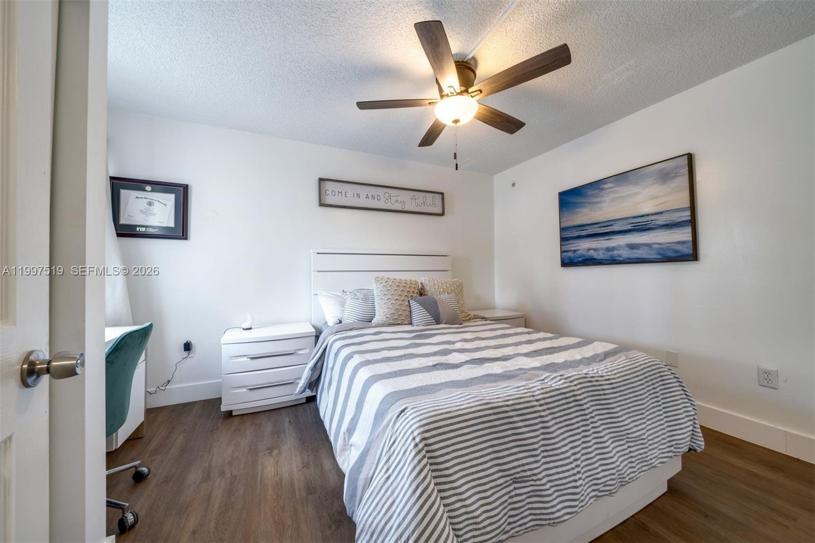 10415 Southwest 154th Court, Unit 2 Miami, FL 33196 - Photo 22 of 27 a bedroom with a large bed and a chandelier