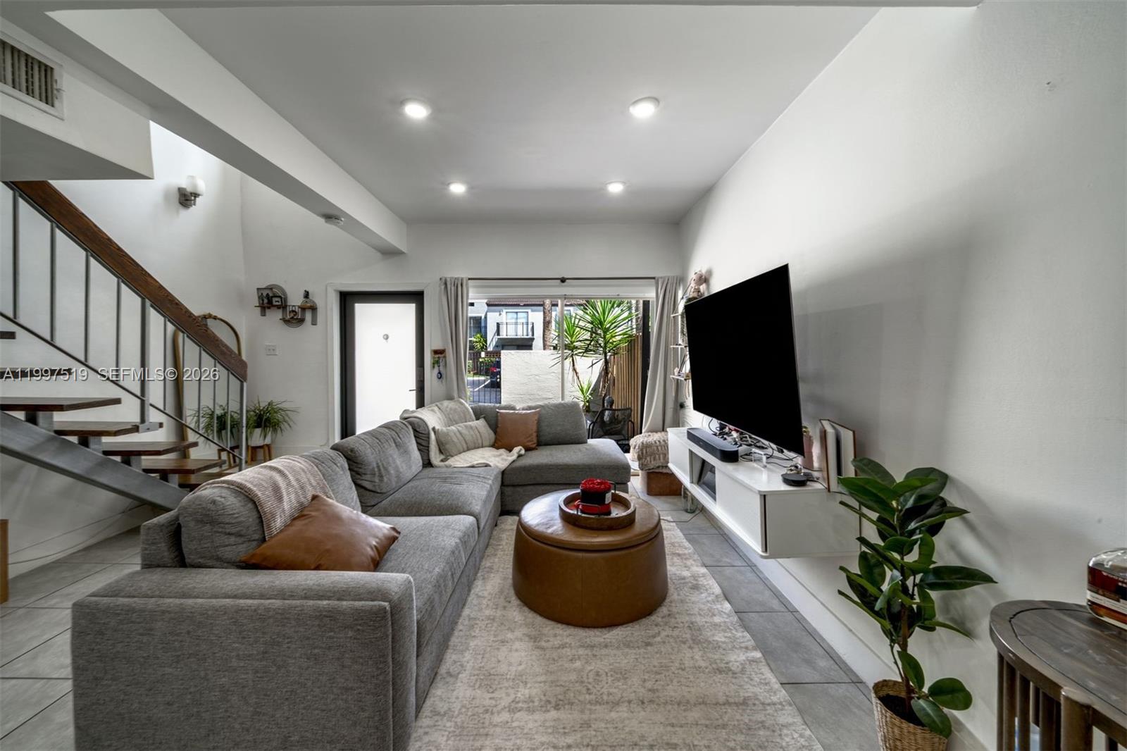 10415 Southwest 154th Court, Unit 2 Miami, FL 33196 - Photo 5 of 27 a living room with furniture and a flat screen tv