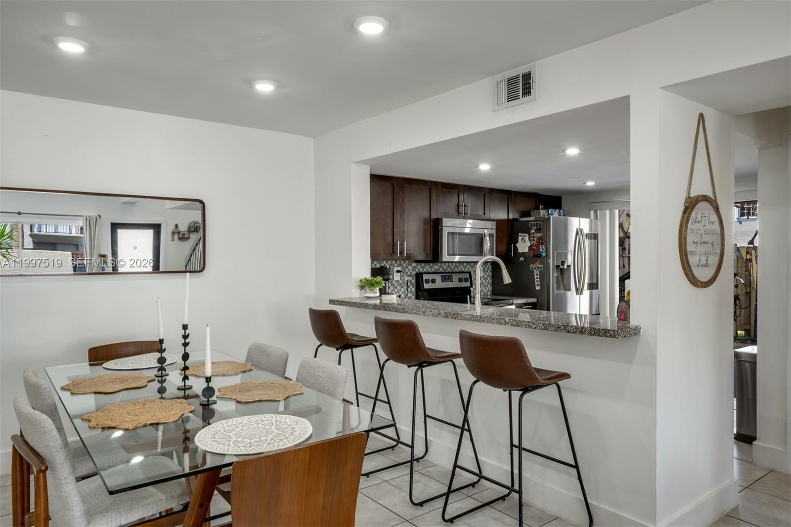 10415 Southwest 154th Court, Unit 2 Miami, FL 33196 - Photo 6 of 27 a living room with furniture a chandelier a kitchen view and a flat screen tv