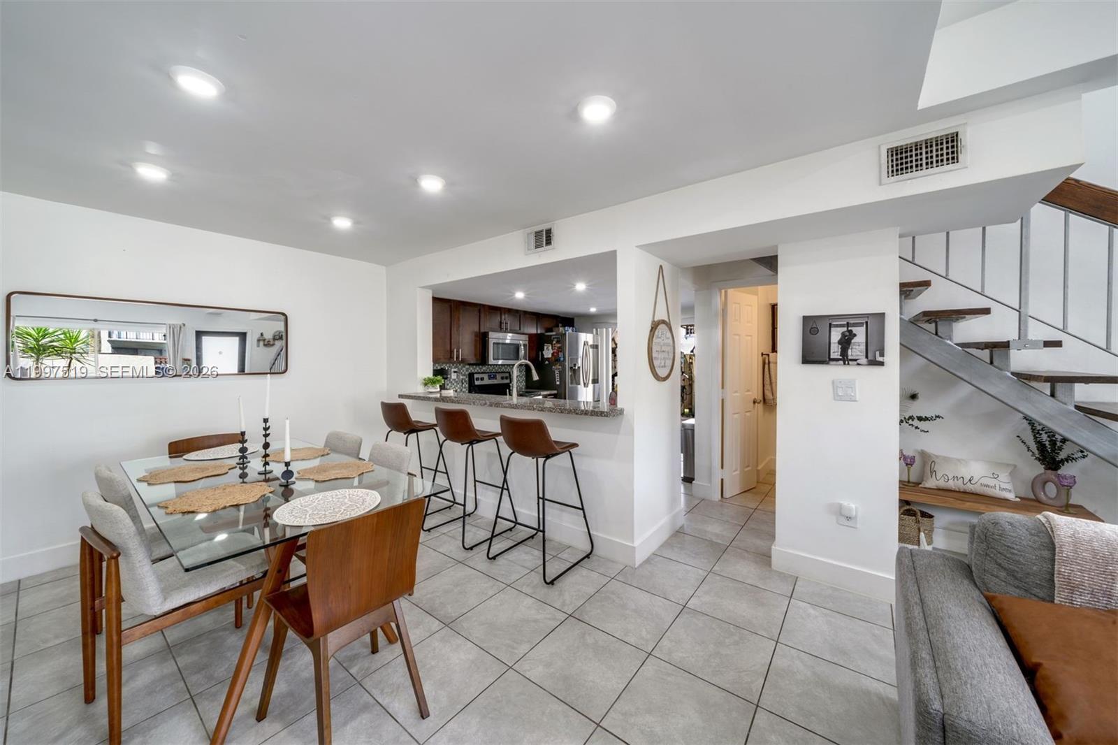 10415 Southwest 154th Court, Unit 2 Miami, FL 33196 - Photo 7 of 27 a living room with furniture and a dining table with wooden floor