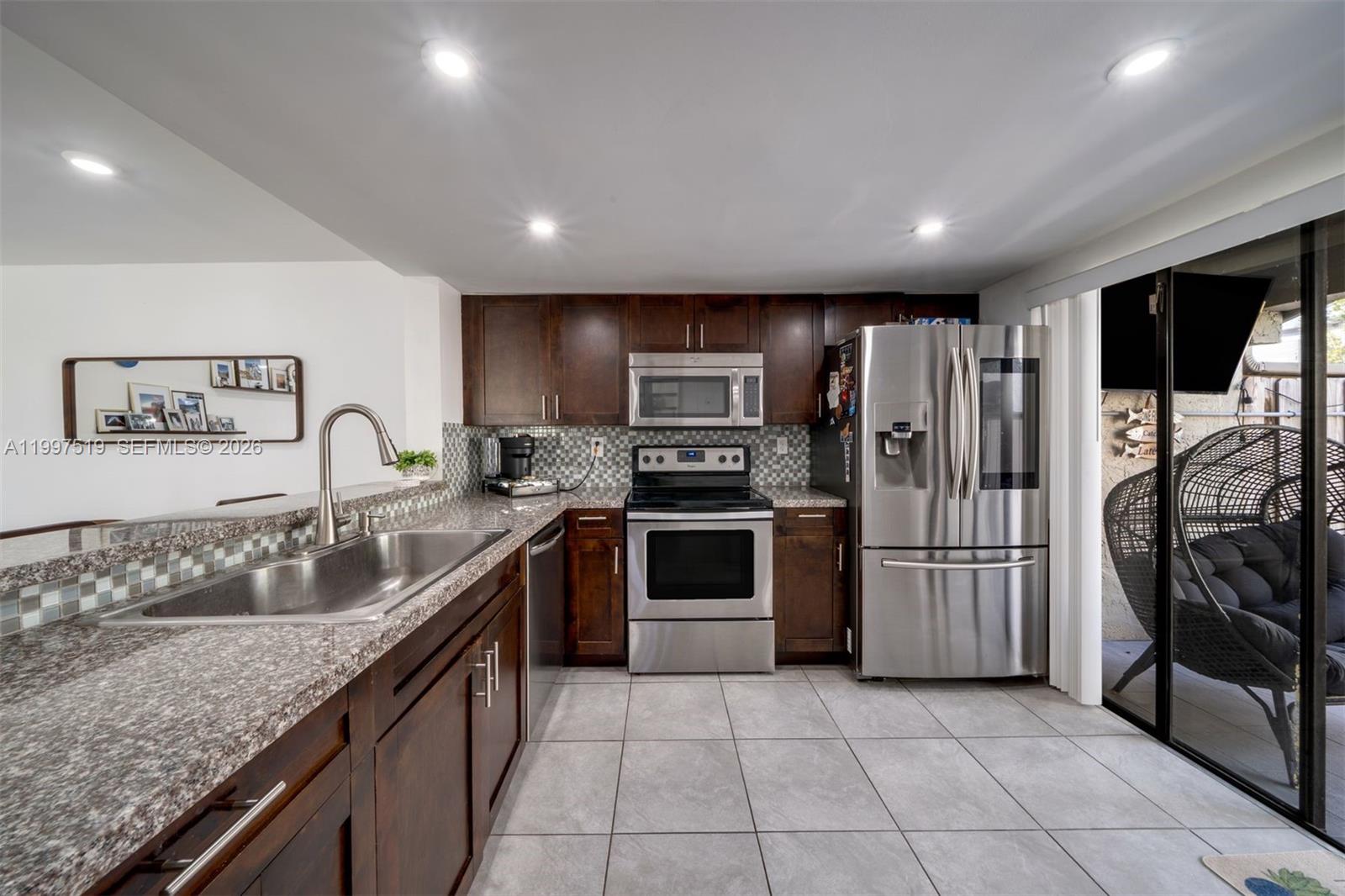 10415 Southwest 154th Court, Unit 2 Miami, FL 33196 - Photo 9 of 27 a kitchen with stainless steel appliances granite countertop a refrigerator and a sink