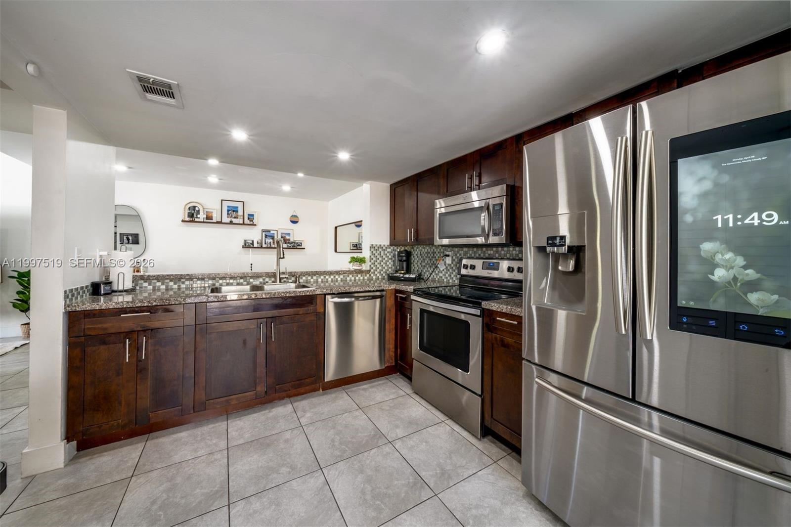 10415 Southwest 154th Court, Unit 2 Miami, FL 33196 - Photo 10 of 27 a large kitchen with a large counter top stainless steel appliances and cabinets