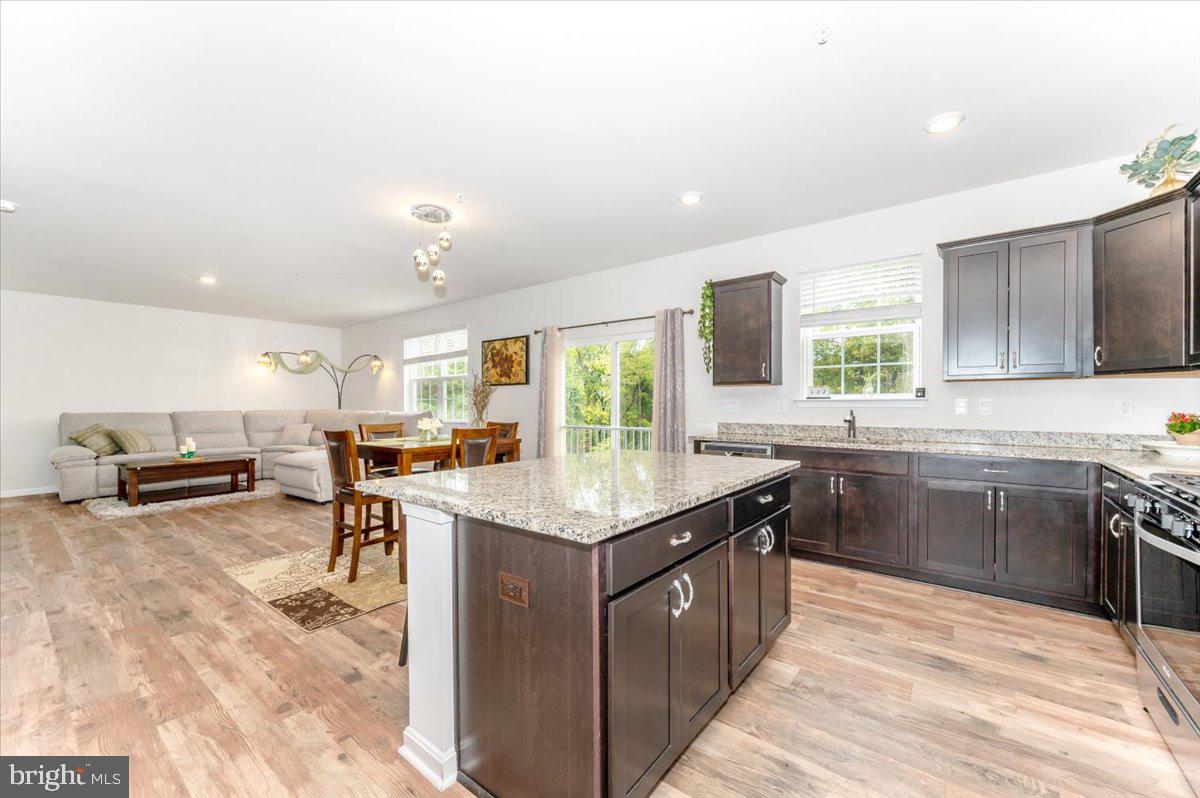 2052 Pomona Way Frederick, MD 21702 - Photo 6 of 71 a kitchen with stainless steel appliances granite countertop a stove top oven a sink dishwasher a dining table and chairs with wooden floor