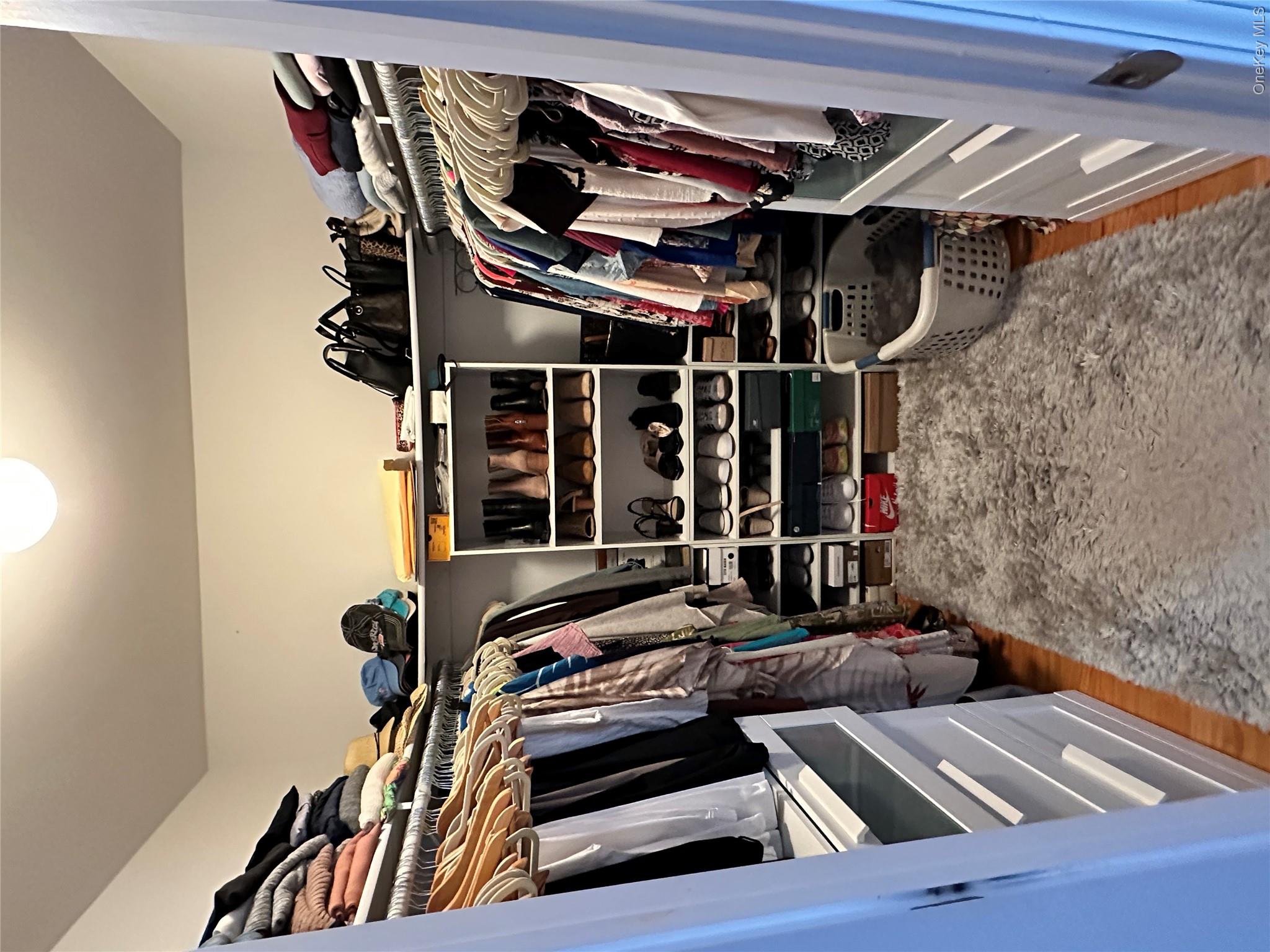 95 Weed Road Pine Bush, NY 12566 - Photo 12 of 31 Walk-in closet featuring hardwood flooring, built-in shelving, hanging rods, and integrated drawer storage