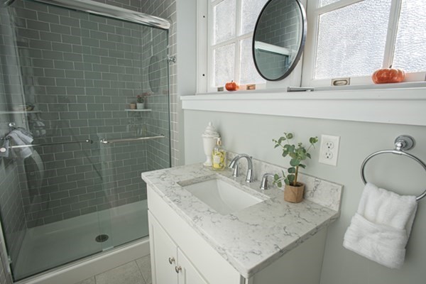 58 Main Street, Unit 4 Hatfield, MA 01038 - Photo 13 of 42 a bathroom with a granite countertop sink a mirror and shower