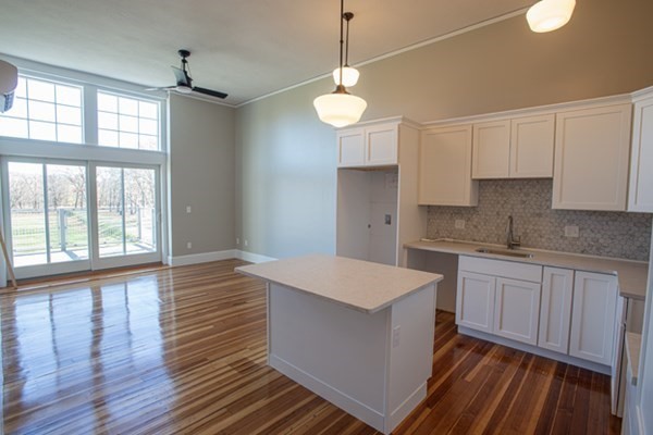 58 Main Street, Unit 4 Hatfield, MA 01038 - Photo 24 of 42 a large kitchen with white cabinets and wooden floor