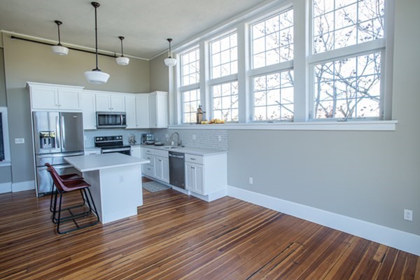 58 Main Street, Unit 4 Hatfield, MA 01038 - Photo 8 of 42 a kitchen with granite countertop wooden floors and white cabinets