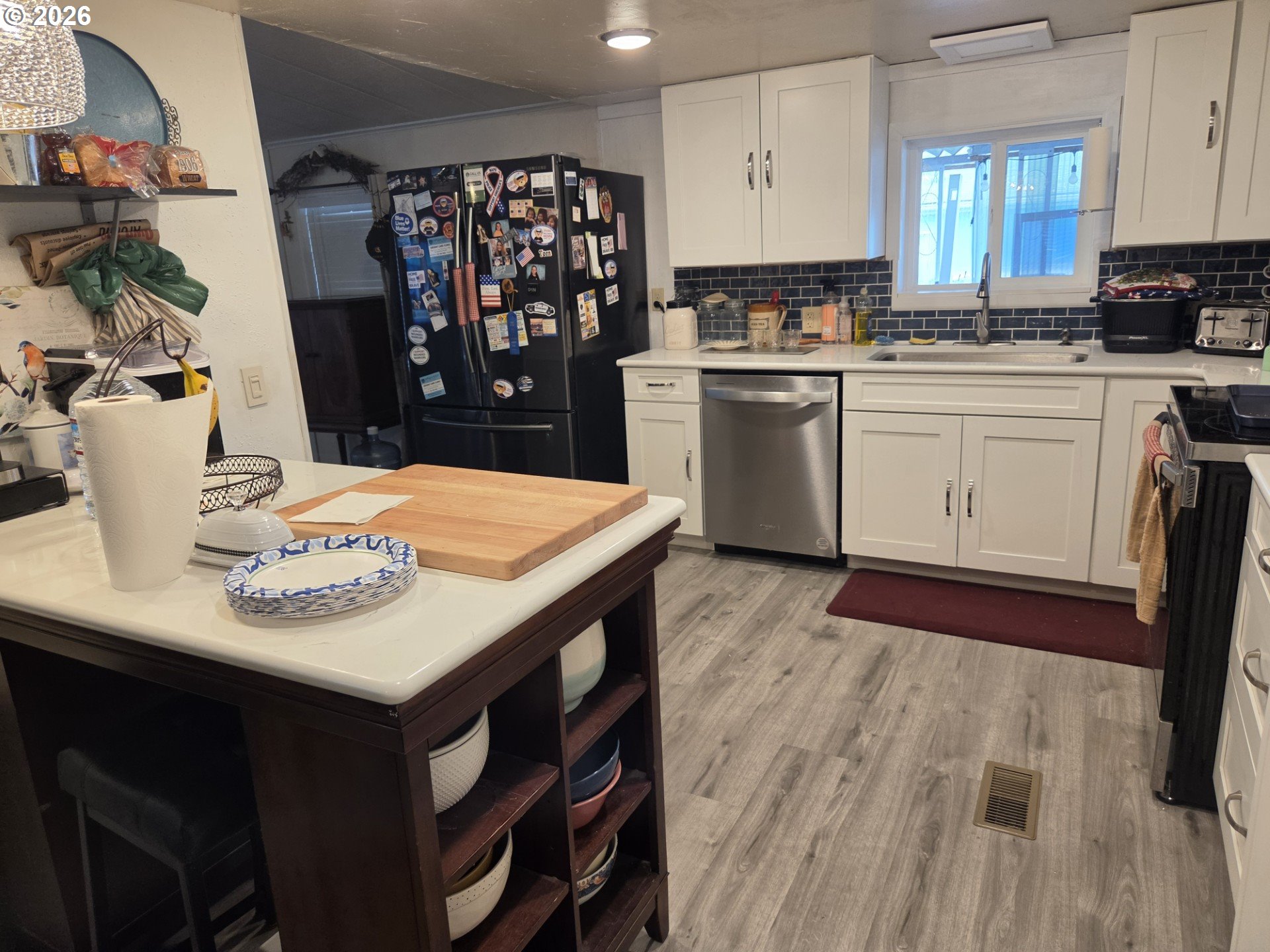 428 South State Street Sutherlin, OR 97479 - Photo 10 of 10 a kitchen with stainless steel appliances kitchen island granite countertop a sink a stove a refrigerator a dining table and chairs
