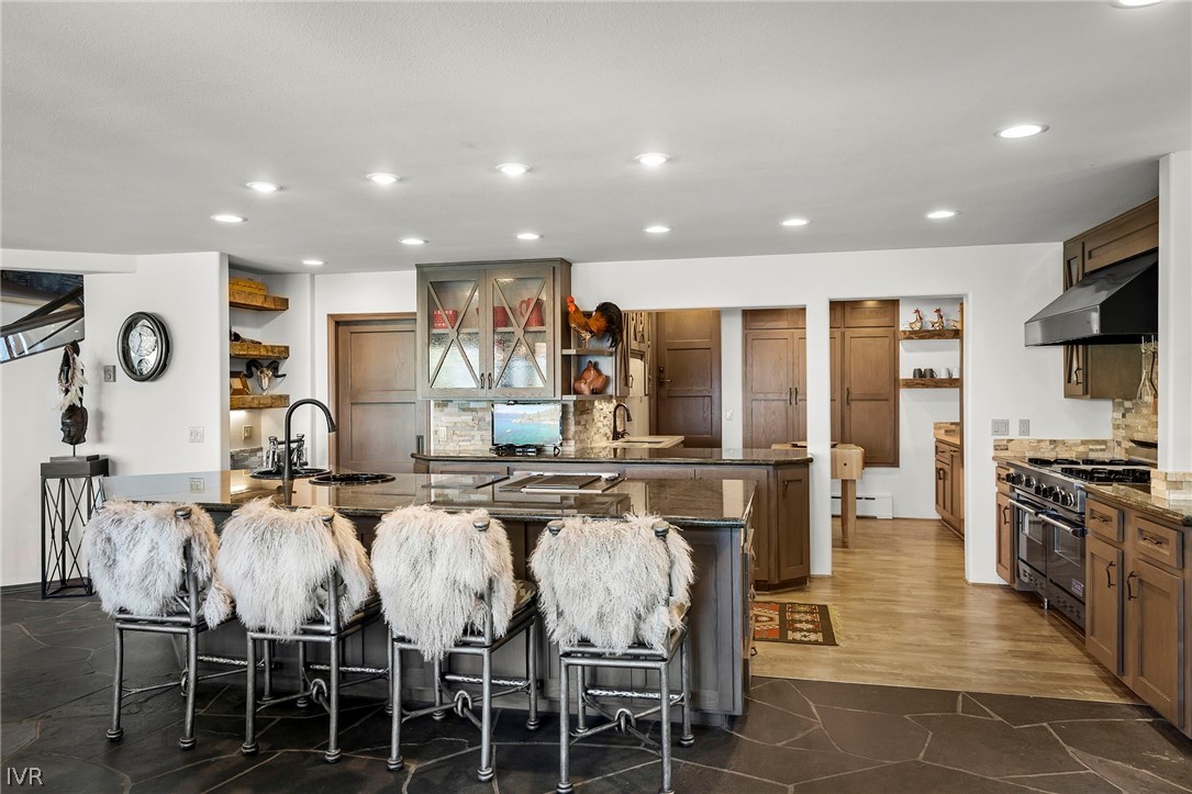 1448 Pittman Terrace Glenbrook, NV 89413 - Photo 17 of 29 a kitchen with stainless steel appliances granite countertop a stove top oven a sink a dining table and chairs