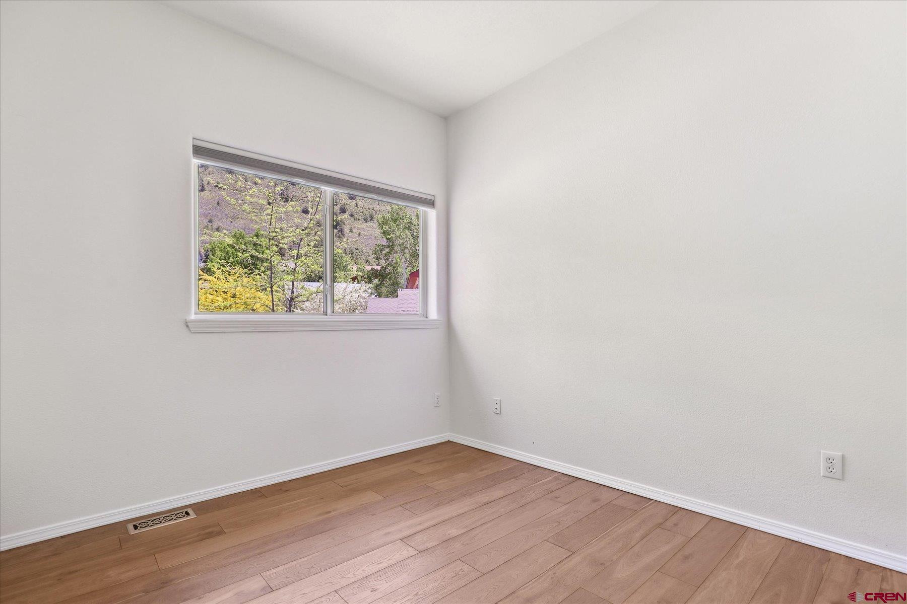 331 Jenkins Ranch Road Durango, CO 81301 - Photo 25 of 35 an empty room with wooden floor and window