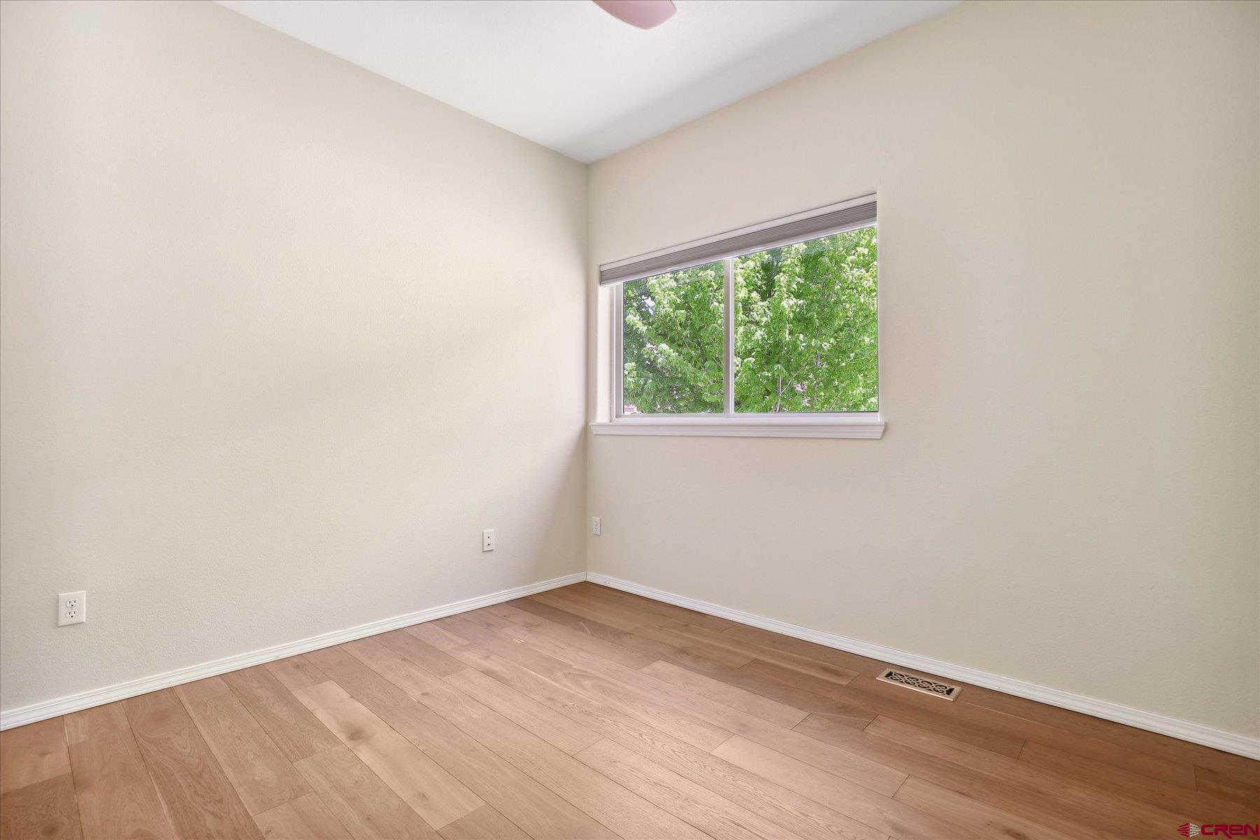 331 Jenkins Ranch Road Durango, CO 81301 - Photo 27 of 35 an empty room with wooden floor and windows