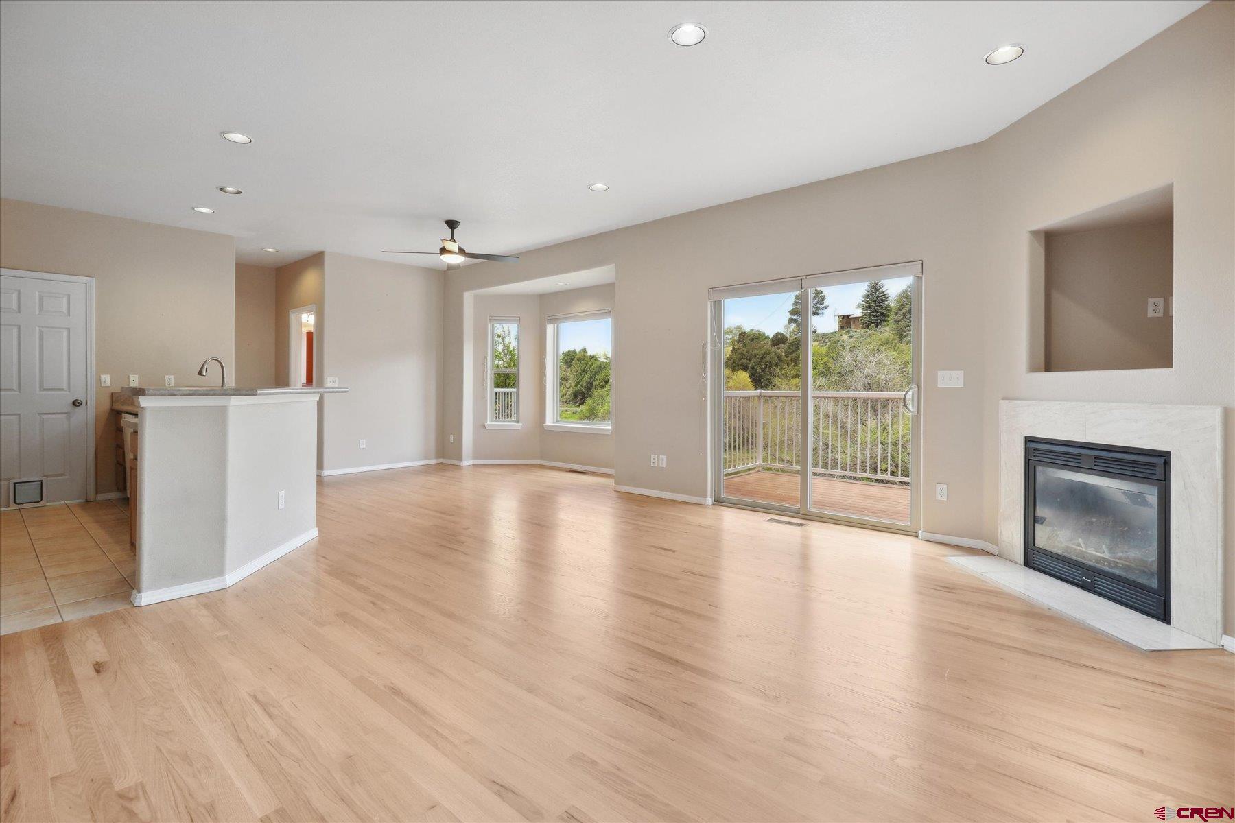 331 Jenkins Ranch Road Durango, CO 81301 - Photo 4 of 35 an empty room with wooden floor and a fireplace