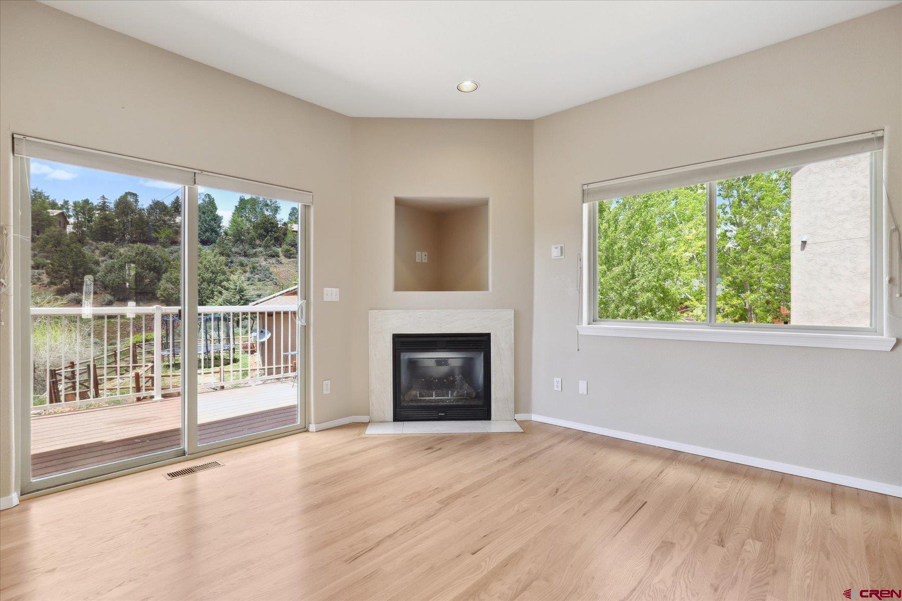 331 Jenkins Ranch Road Durango, CO 81301 - Photo 6 of 35 wooden floor fireplace and windows in an empty room