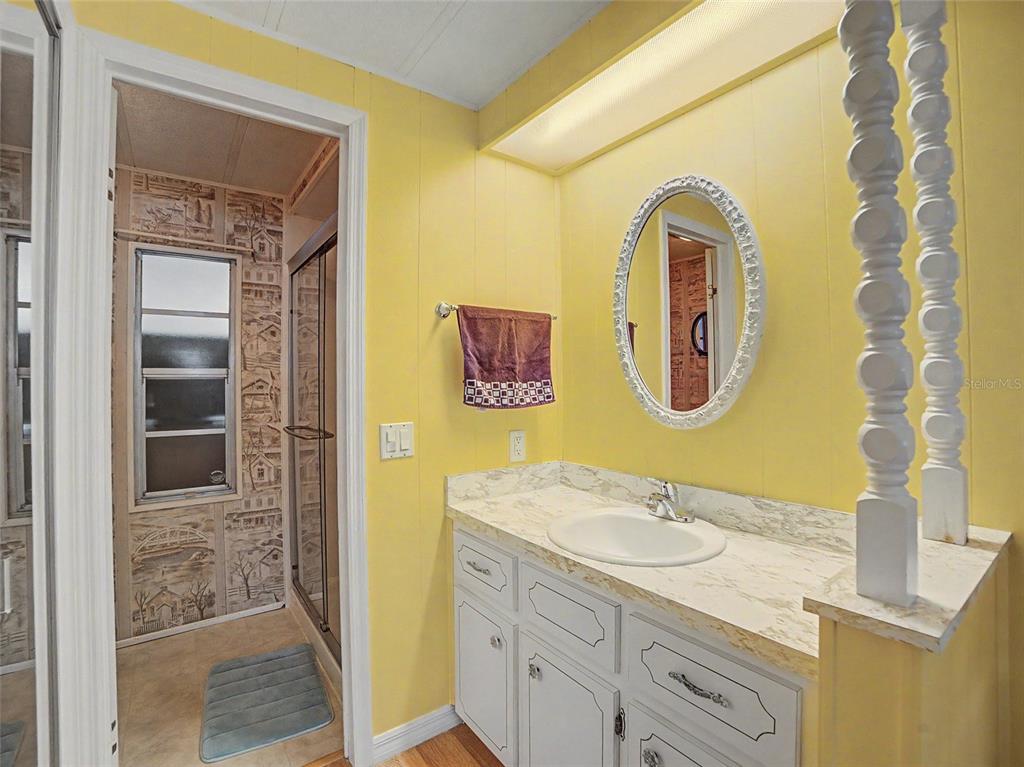 701 Sugar Palm Street Largo, FL 33770 - Photo 15 of 35 a bathroom with a granite countertop sink a mirror and a shower