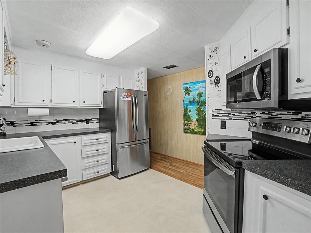 701 Sugar Palm Street Largo, FL 33770 - Photo 6 of 35 a kitchen with granite countertop a stove sink and refrigerator