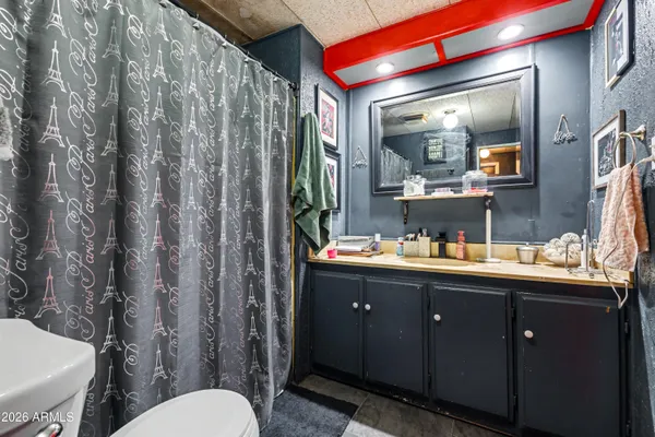 a bathroom with a granite countertop sink toilet and mirror