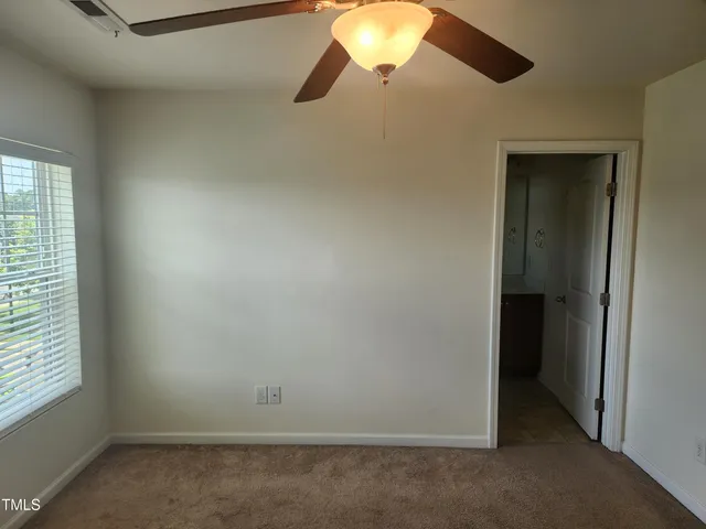 an empty room with a window and a ceiling fan