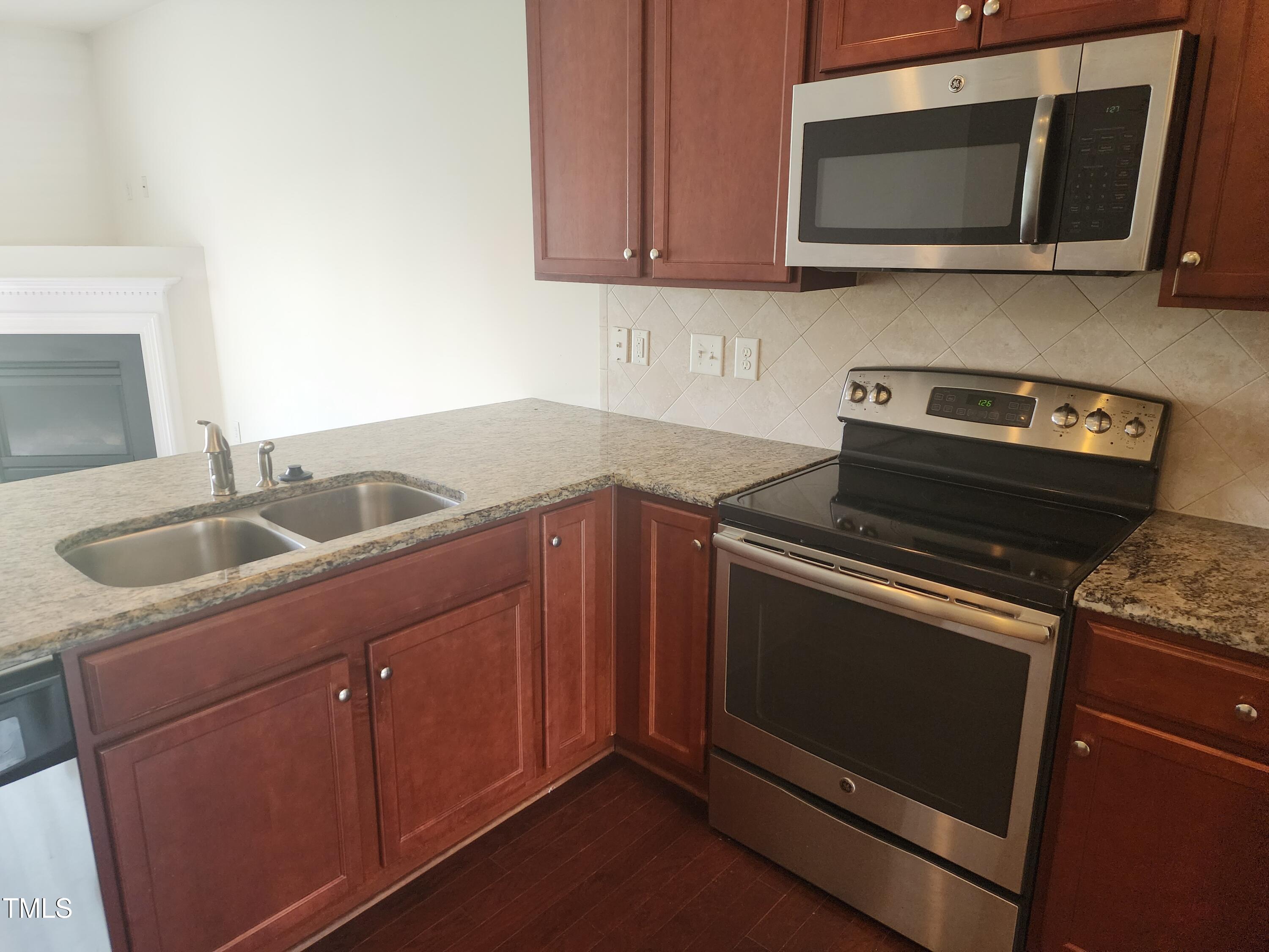 1304-107 Cozart Street, Unit 107 Durham, NC 27704 - Photo 2 of 15 a kitchen with stainless steel appliances granite countertop a stove microwave and sink
