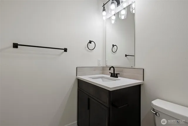 a bathroom with a sink a toilet and mirror